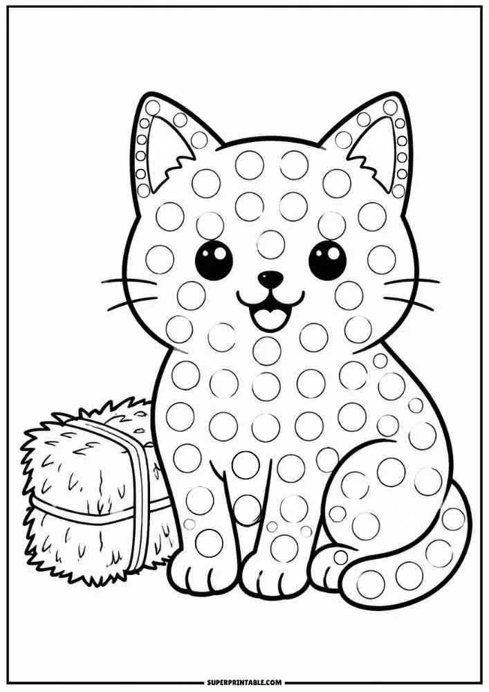 Black and white kitten beside a hay bale with dot circles.