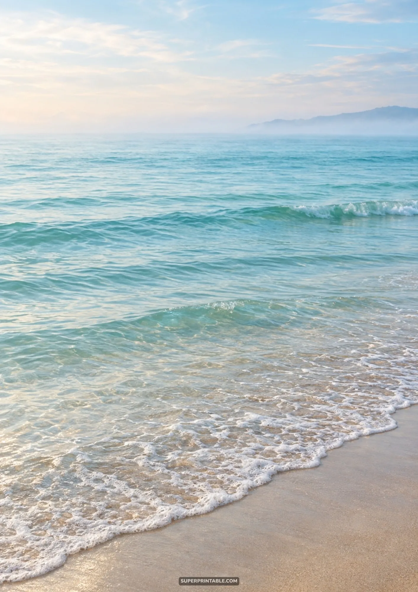 Gentle crystal-clear turquoise ocean waves lapping softly onto sunlit golden beach sand