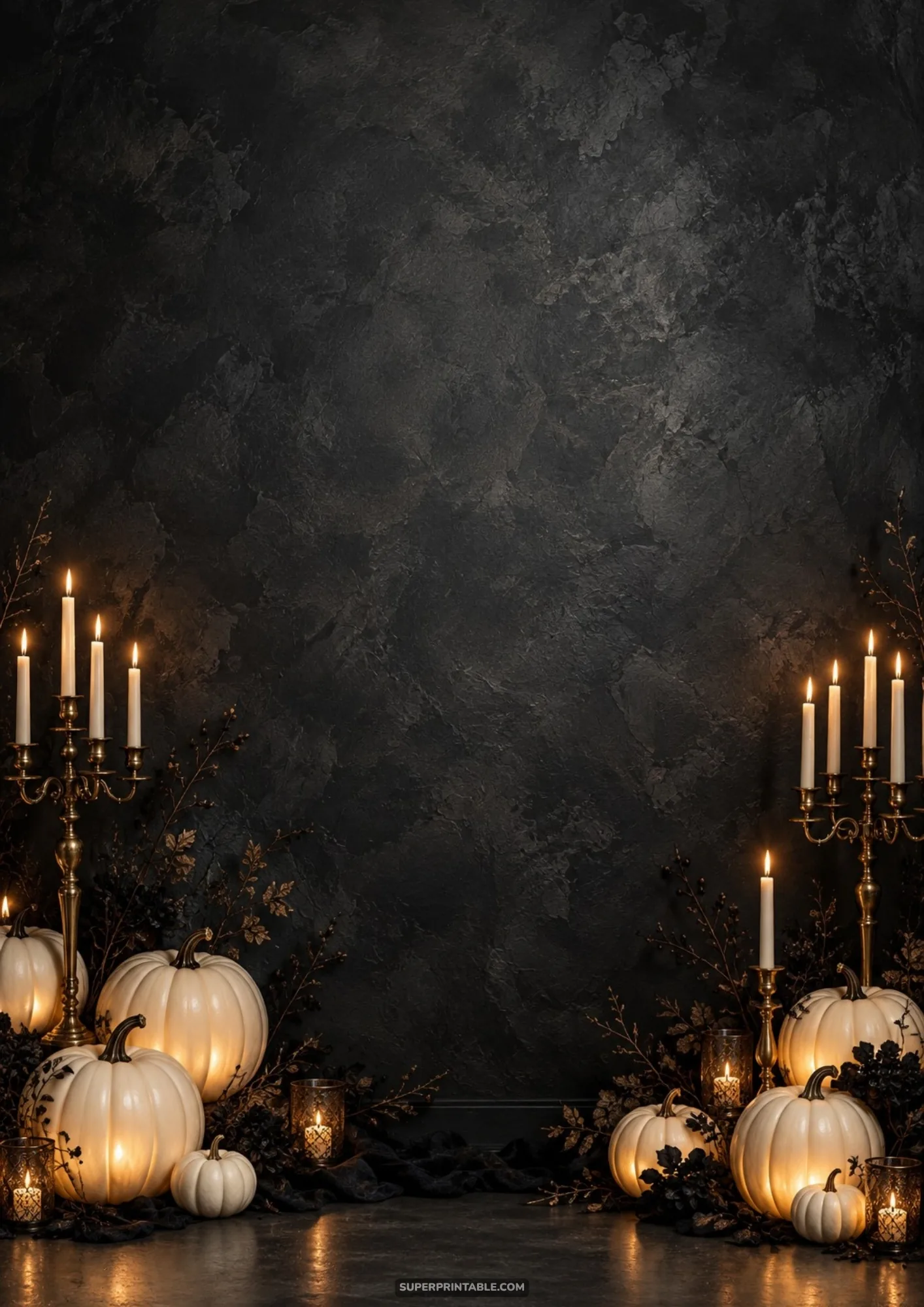 Elegant brass candelabras and glowing white pumpkins arranged along a textured dark charcoal wall